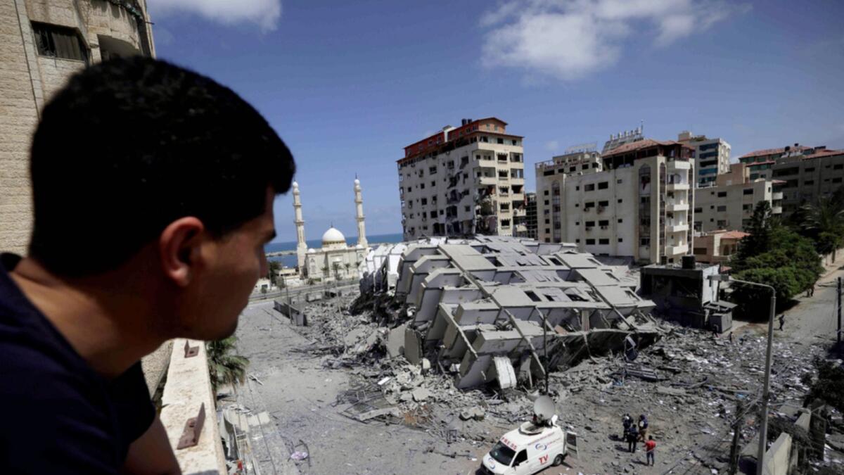 A Palestinian man looks at a destroyed building in Gaza City, following a series of Israeli airstrikes on the Gaza Strip on May 12. — AFP