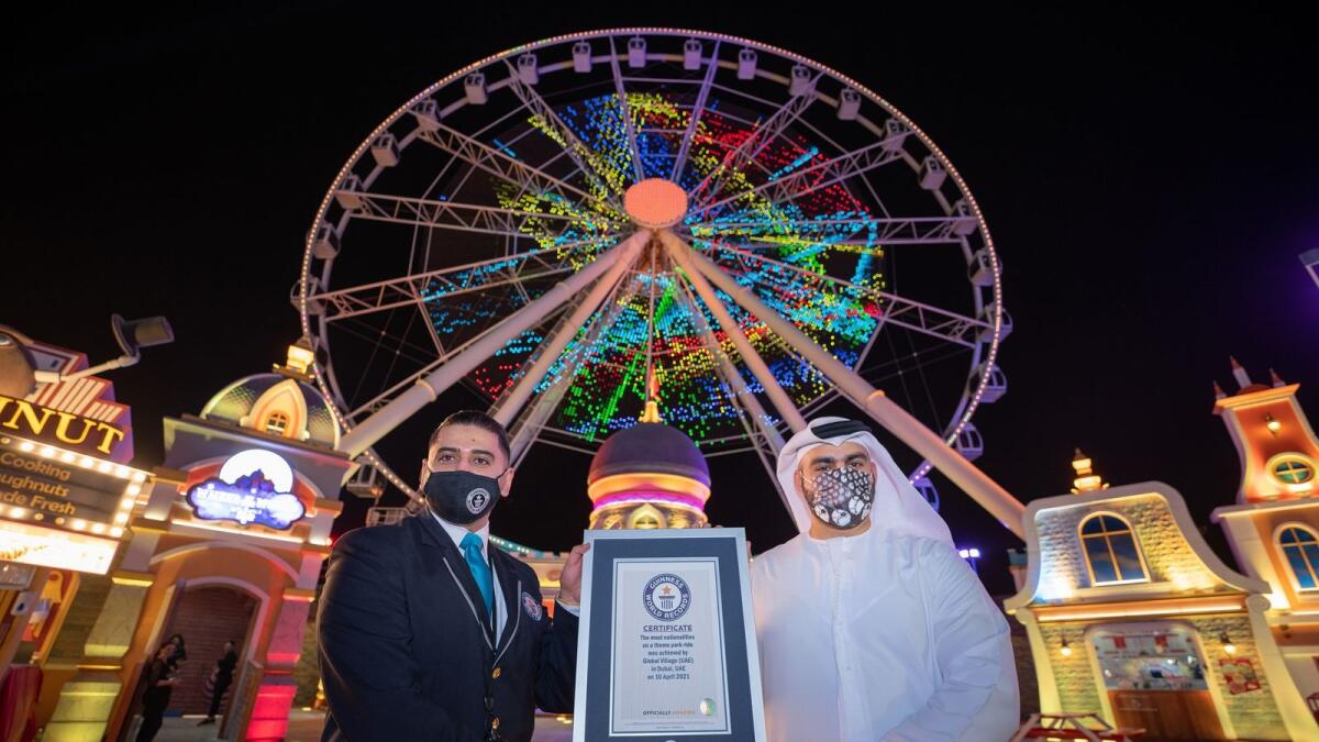 Official at Global Village display the Guinness World Records certificate for most nationalities on a theme park ride. Supplied photo.