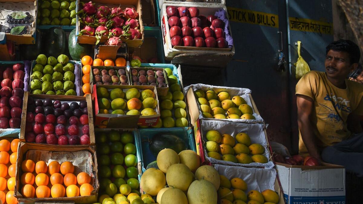 A fruit vendor waits for customers at a stall in Mumbai. Moody's said the weakening Indian rupee and high oil prices will continue to exert upward pressure on inflation. - AFP