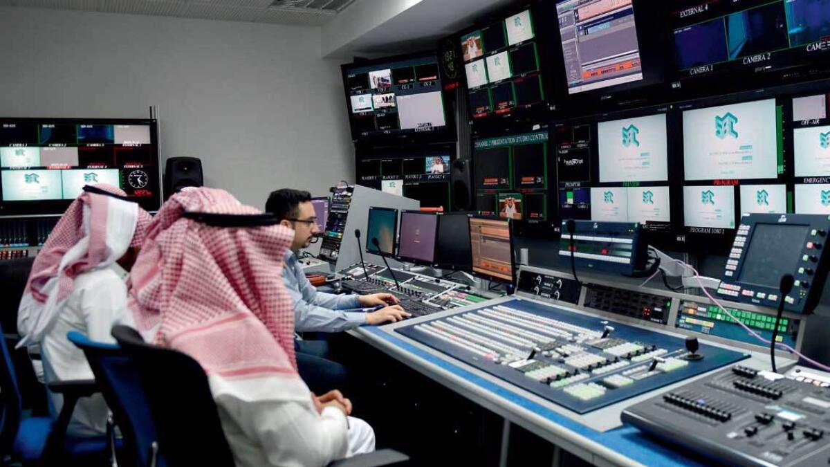 An employee works with trainees at the studio of the new channel Saudi Broadcasting Corporation in Riyadh. — AFP
