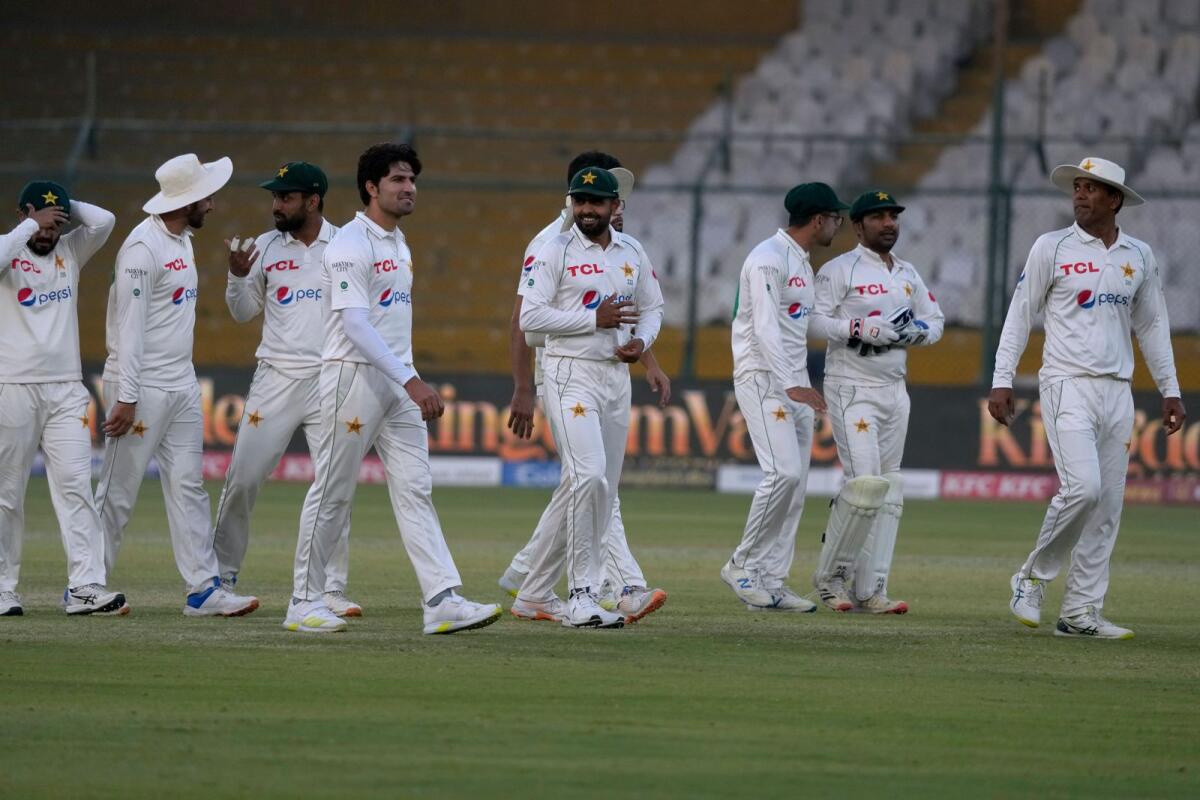 Pakistan's Babar Azam (centre) and teammates walk off the field after the end of the first Test against New Zealand. — AP