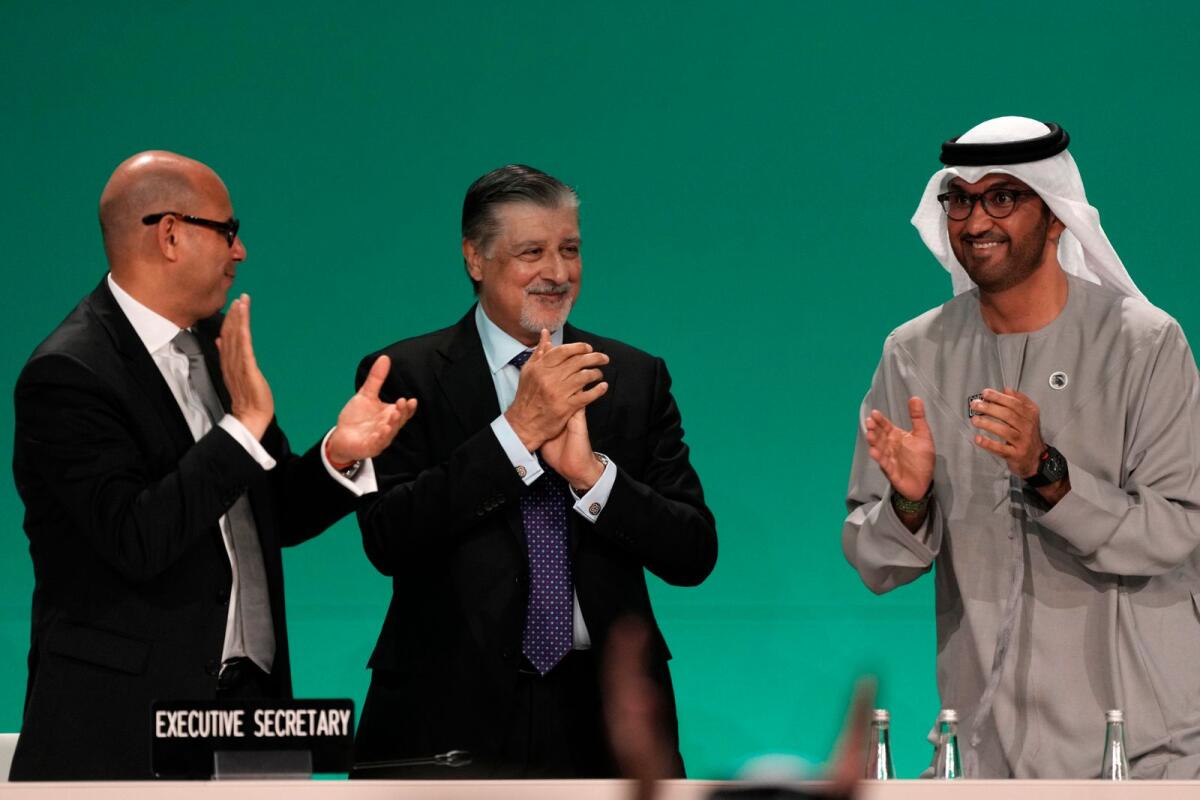 COP28 President Sultan al-Jaber, right, celebrates passing the global stocktake with United Nations Climate Chief Simon Stiell, left, and COP28 CEO Adnan Amin.Photo: AP