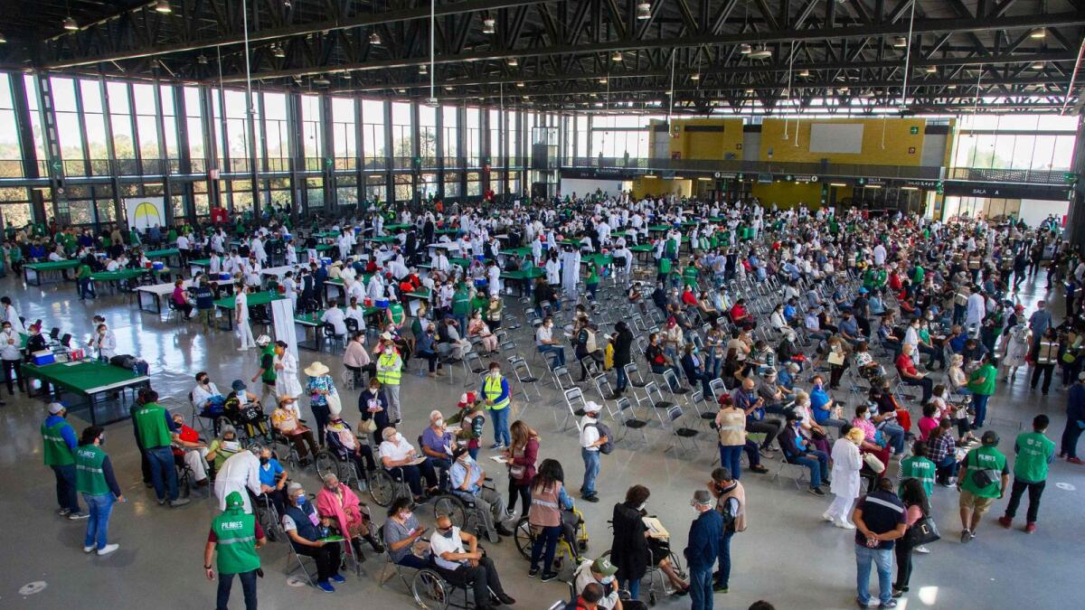 People wait to receive a dose of the Pfizer-BioNTech vaccine against Covid-19 at the vaccination centre set up at the University City Exhibition Centre and Congress in Coyoacan, Mexico City.