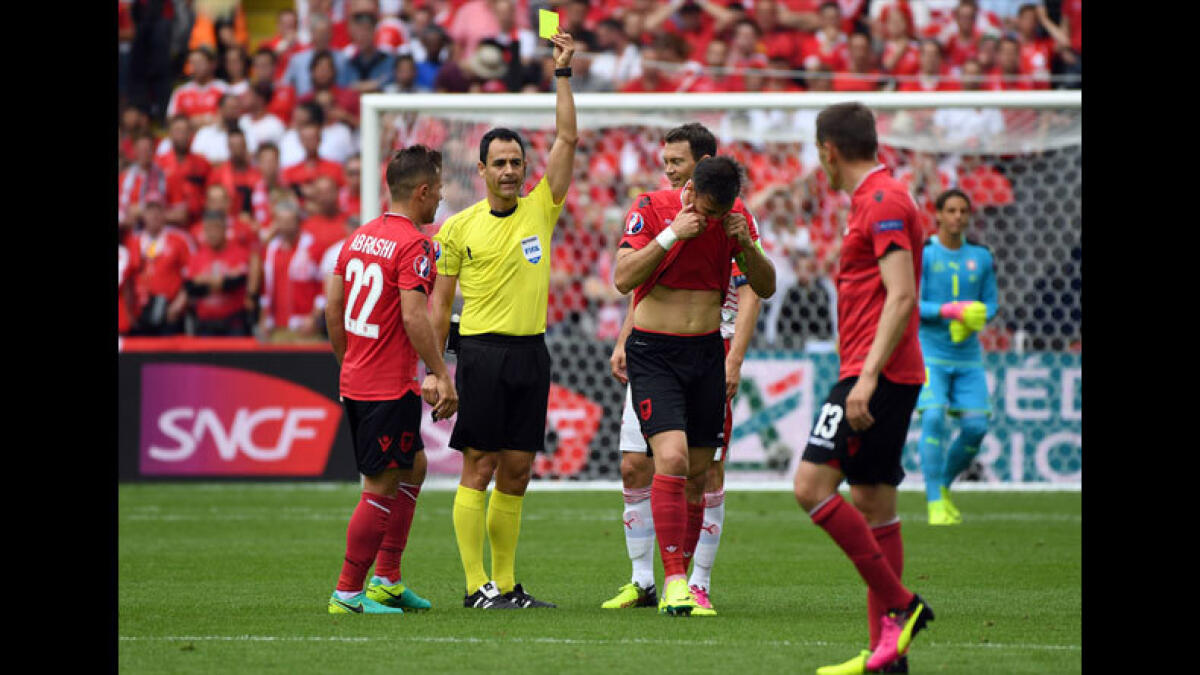 Referee Carlos Velasco Carballo shows a yellow card to Albania's Lorik Cana, 2nd right. (AP)