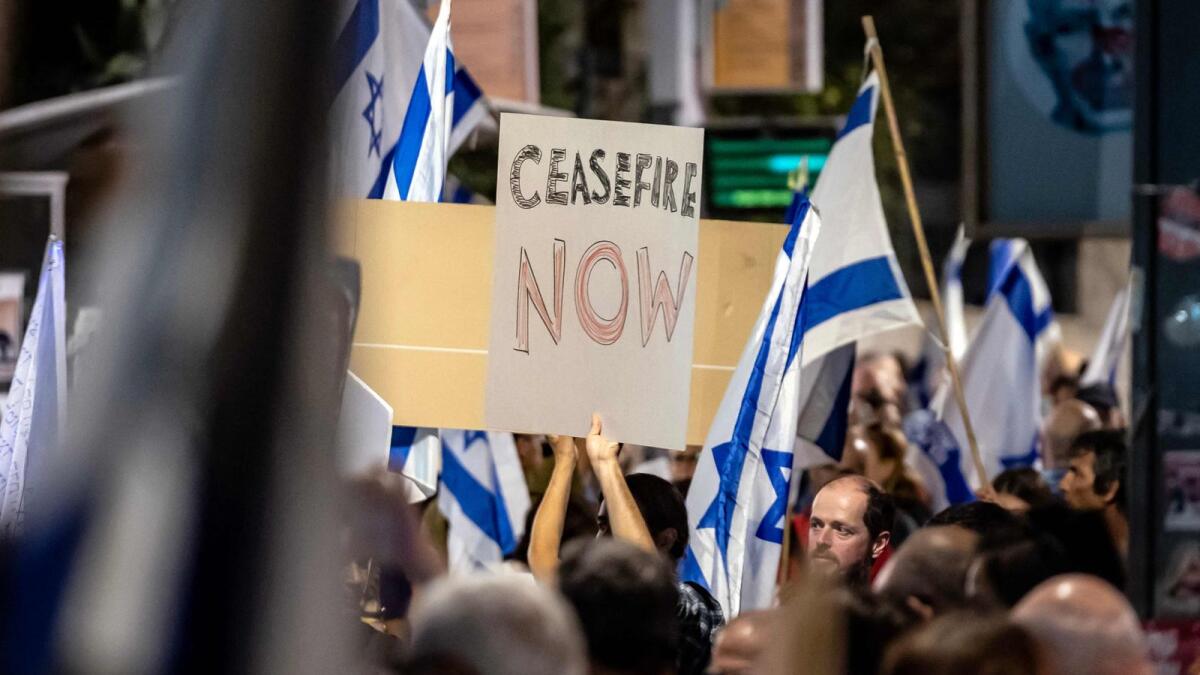 Israeli demonstrators hold signs and flags during an anti-government protest in Jerusalem on November 4, 2023. AFP