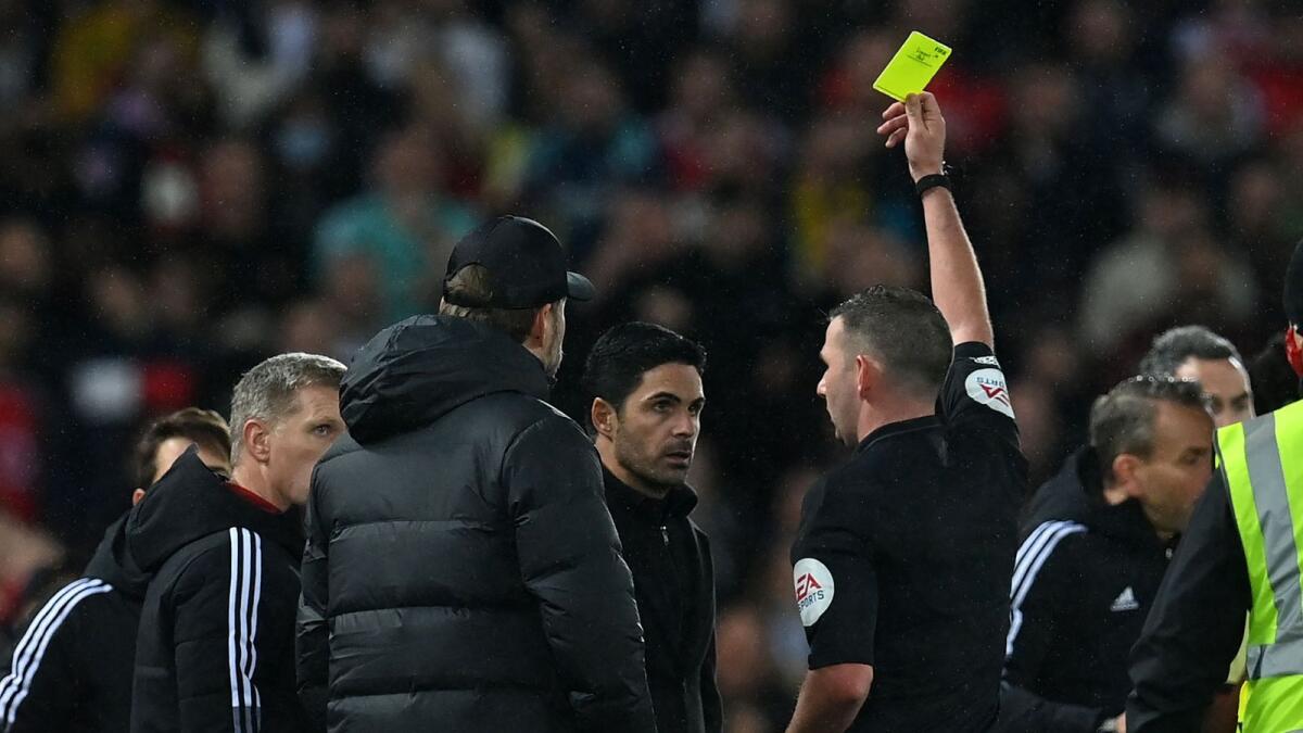 Arsenal manager Mikel Arteta (centre) and Liverpool manager Juergen Klopp (centre left) are booked by referee Michael Oliver after a clash on the touchline during the Premier League match. (AFP)