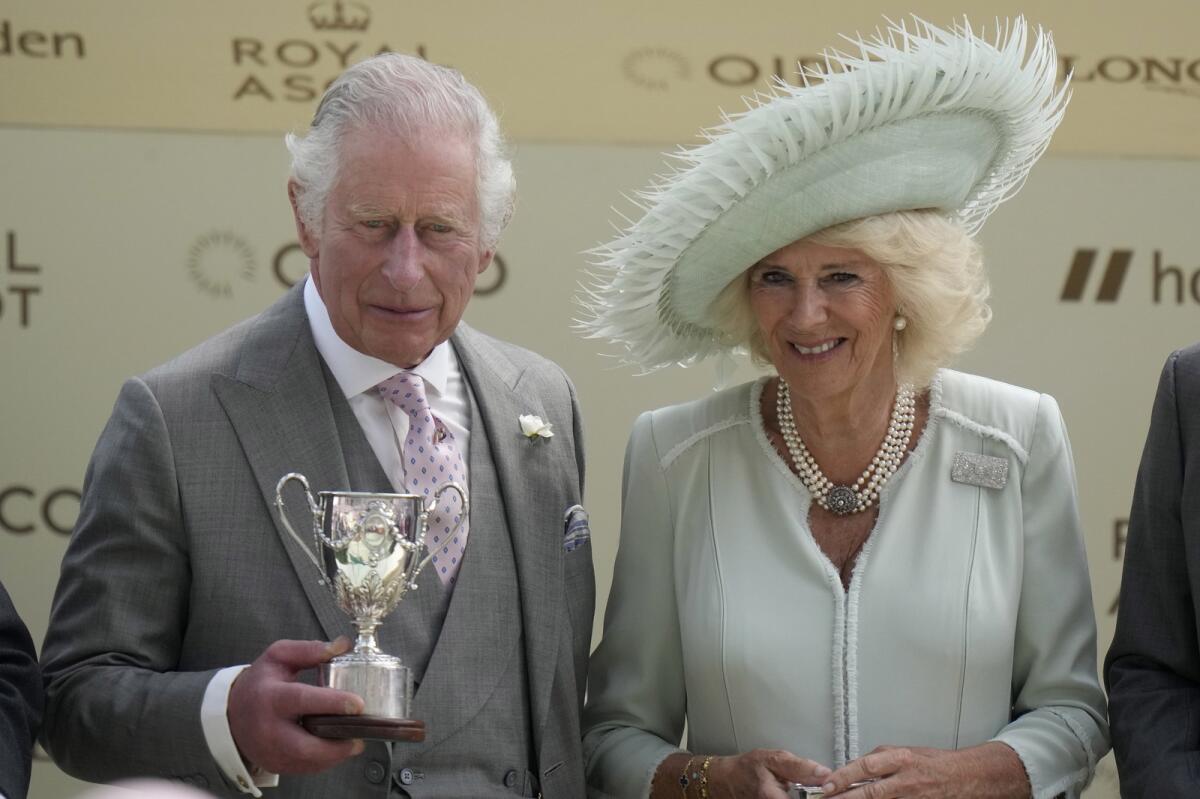 King Charles III and Queen Camilla with the King George V Stakes trophy. - AP