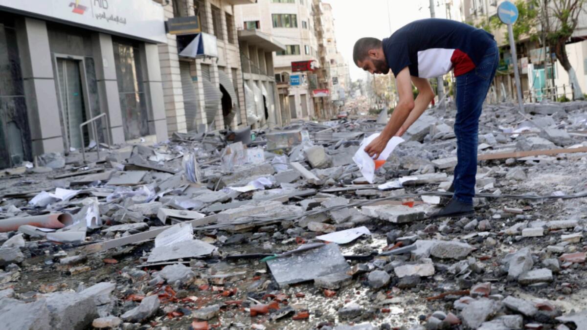 A man inspects the rubble of destroyed commercial building and Gaza health care clinic following an Israeli air strike. — AP