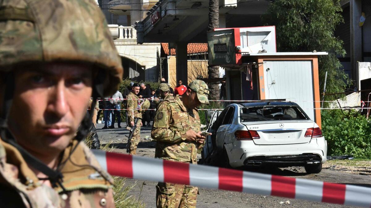 Lebanese army soldiers secure the area around a car wrecked in a reported Israeli drone strike in the village of Jadra between Beirut and the southern city of Sidon. — AFP