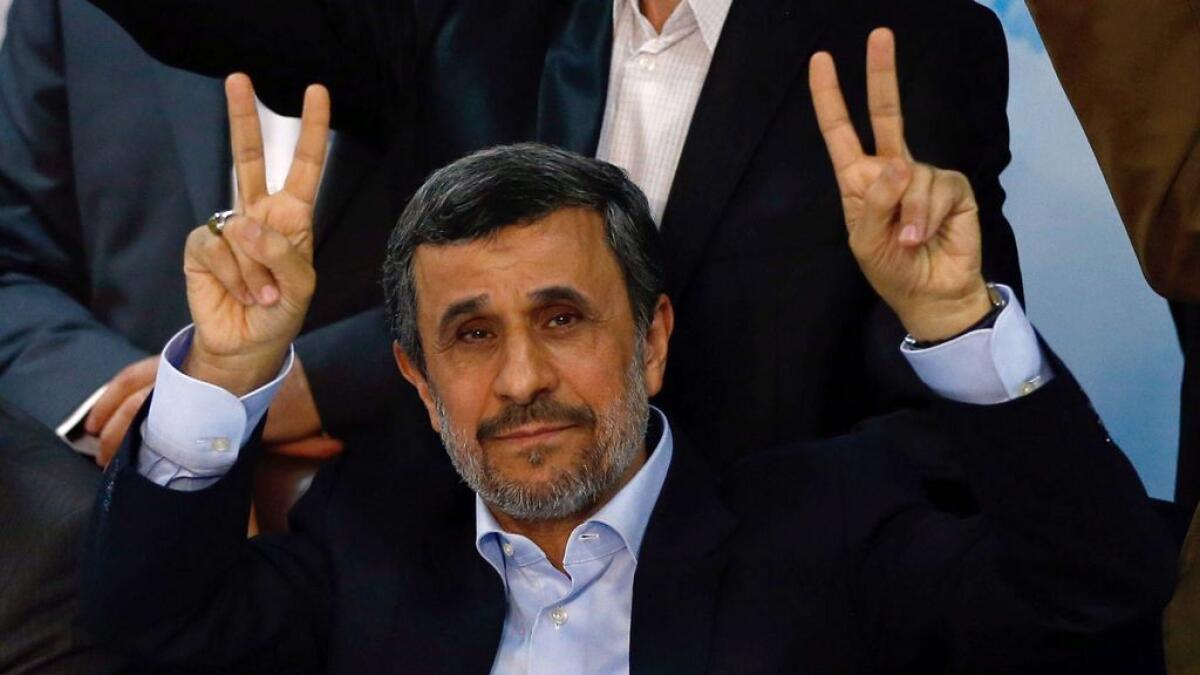 Former Iranian president Mahmoud Ahmadinejad (C) flashes the sign for victory 