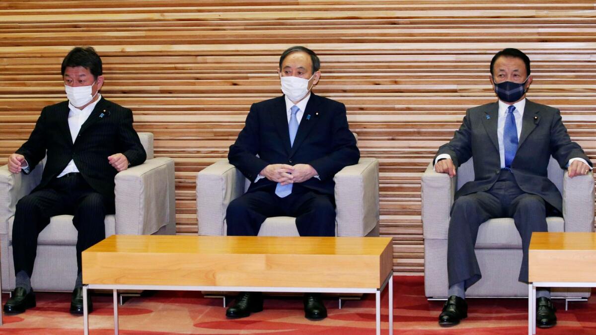 Japanese Prime Minister Yoshihide Suga (centre) Foreign Minister Toshimitsu Motegi  (left) and Finance Minister Taro Aso sit before attending a cabinet meeting at the prime minister's official residence in Tokyo. Japan is set to extend a coronavirus state of emergency in Tokyo and other areas with infections not yet slowing to levels it can safely host the Olympics opening in just over 50 days. — AP