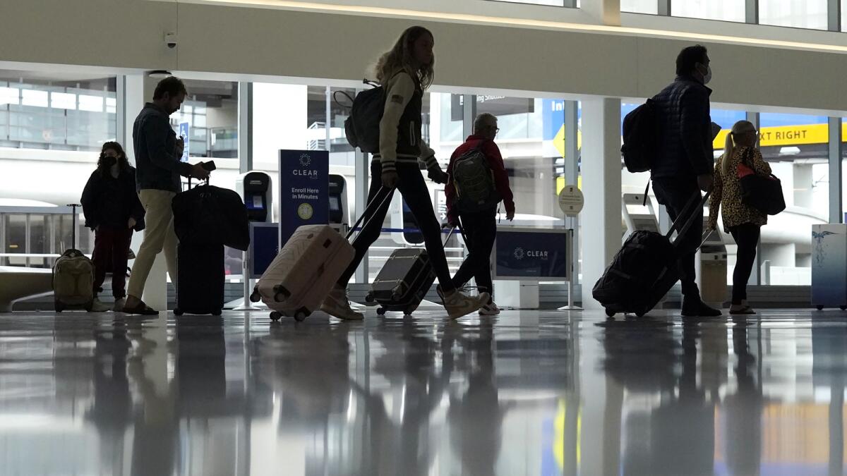 Travellers walk through a domestic terminal at San Francisco International Airport in San Francisco. — AP
