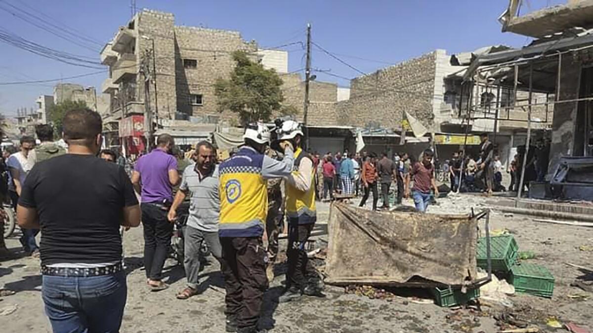Syrian White Helmet civil defence workers gather with civilians at the rocket attacked scene at Al Bab town. — AP