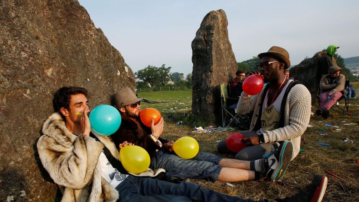 Festival goers inhale laughing gas at sunrise at the stone circle on the second day of Glastonbury music festival at Worthy Farm in Somerset. — Reuters file