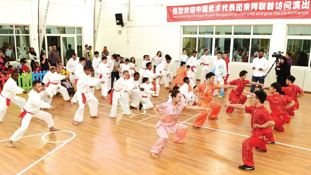 Rashid Centre students (in white) learn Wushu horse-riding stance from visiting Chinese martial arts champions. — Supplied photo