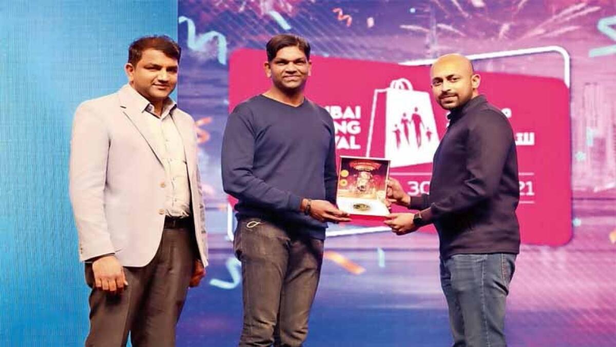 Dileep P. Nair, marketing manager, Joyalukkas Jewellery and John Paul Alukkas, handing a quarter kg gold bar to Riyaz PC.