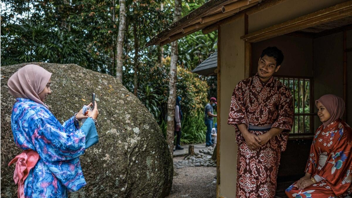Visitors wearing traditional Japanese-themed attire take pictures in the Japanese Village, which showcases a series of Japan-inspired attractions spread across a garden landscape on a hilltop, in Berjaya Hills in Bukit Tinggi, in Malaysia's Pahang state. Photo: AFP