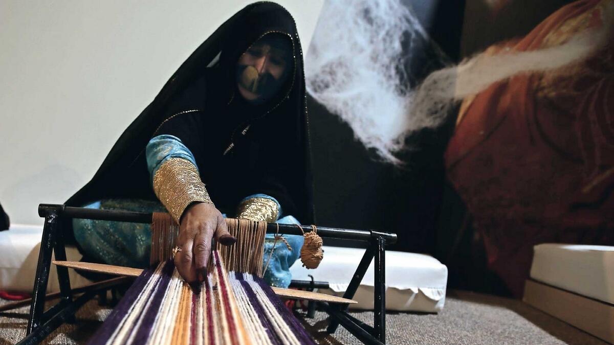 An Emirati woman at the House of Artisans demonstrates the art of weaving during a media tour of Qasr Al Hosn in Abu Dhabi on Sunday. — Photo by Ryan Lim