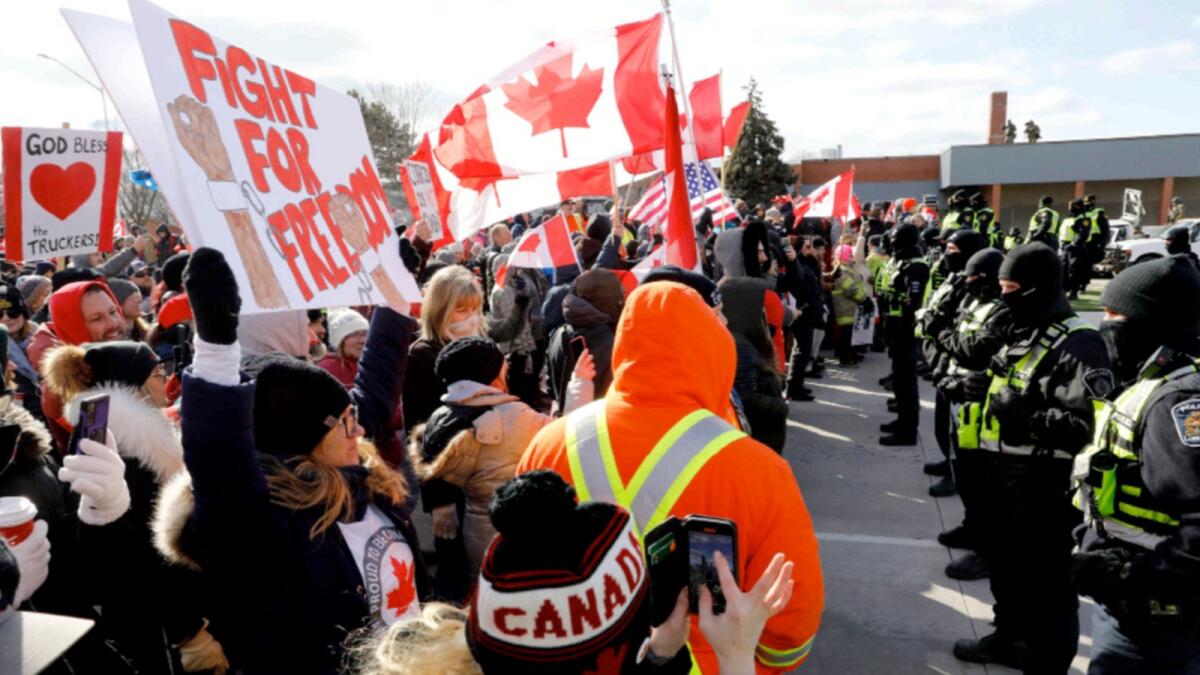 Protestors confront the Ontario Provincial Police as they try to clear the entrance to the Ambassador Bridge in Windsor, Ontario. — AFP