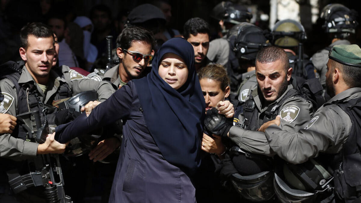 Israeli security forces arrest a Palestinian woman during clashes between Palestinian protesters and Israeli police.