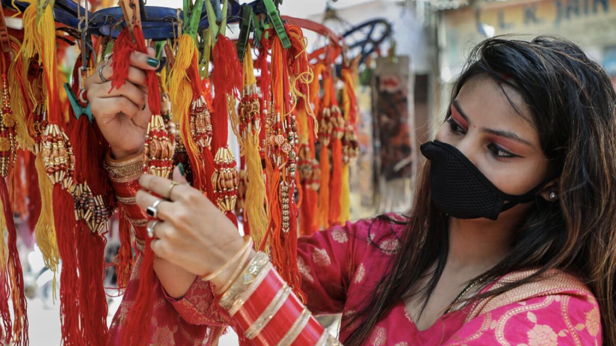 A young woman purchases 'rakhi' ahead of Raksha Bandhan festival, in Jammu. Photo: PTI