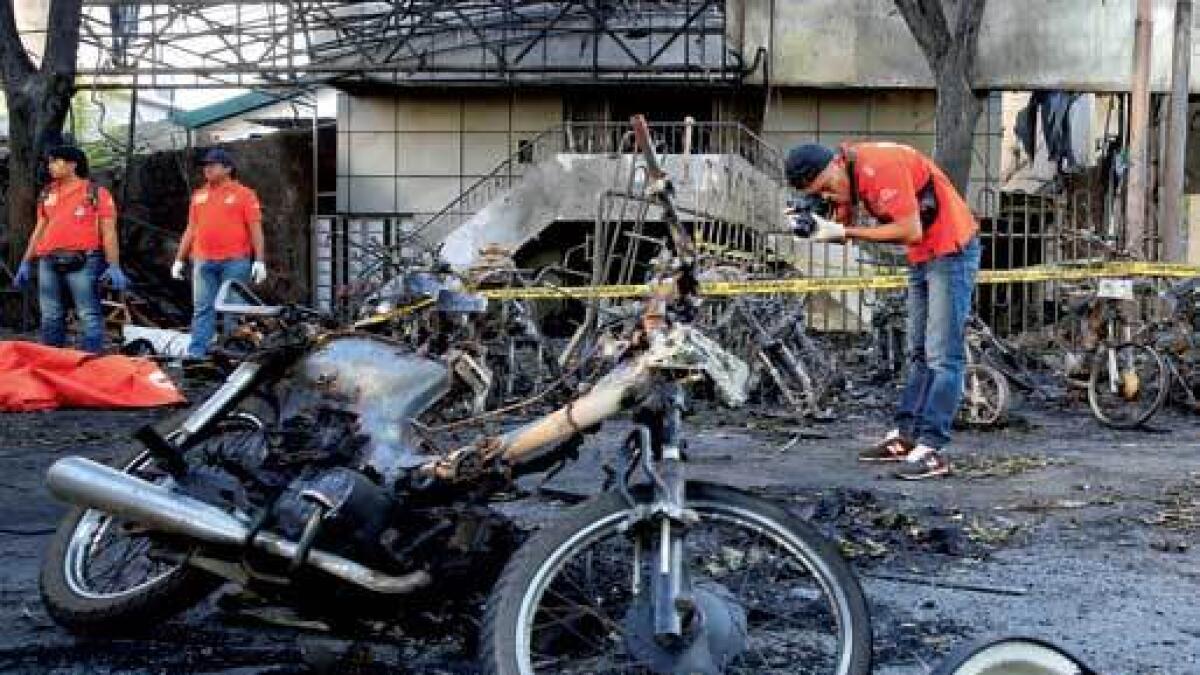 BLAST SITE: Forensic officers working at the Pentecost Church in Indonesia on Sunday. — Reuters