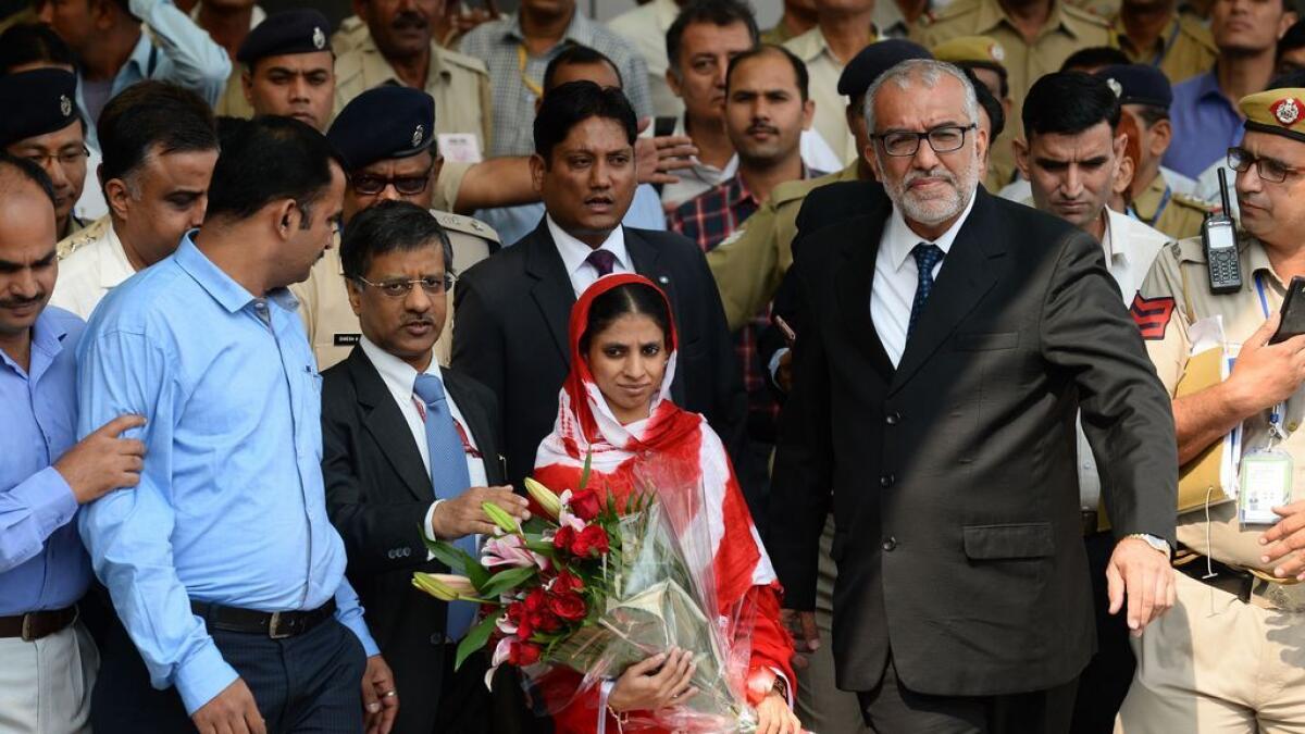 Geeta (C) is escorted by officials as she leaves the Arrivals Hall of Indira Gandhi International Airport in New Delhi.