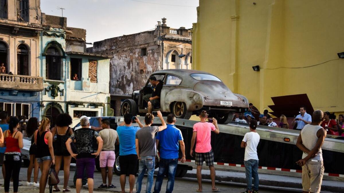 Cubans look at the cars used in the shooting of Fast and Furious 8.