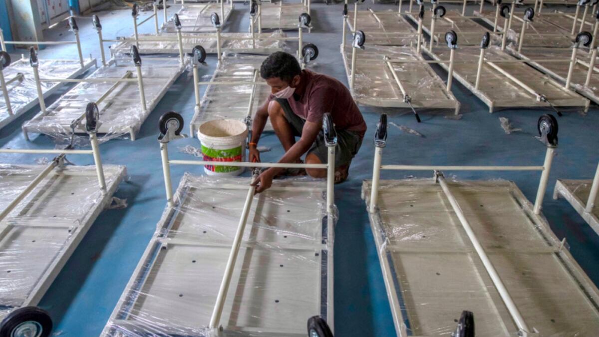 A workers installs a beds at a makeshift Covid-19 care centre with 1200 beds in Mumbai. — AP