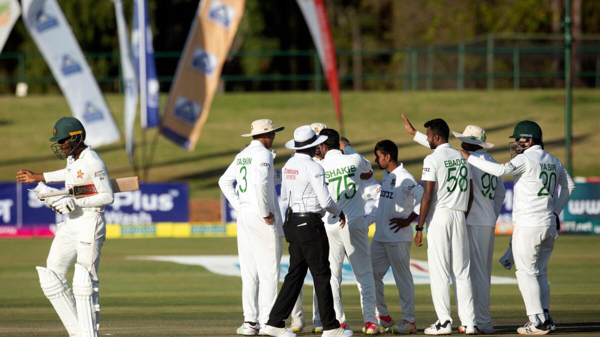 Zimbabwe batsman Milton Shumba (left) walks off the pitch after been dismissed on the second  day of the one-off Test. — AP