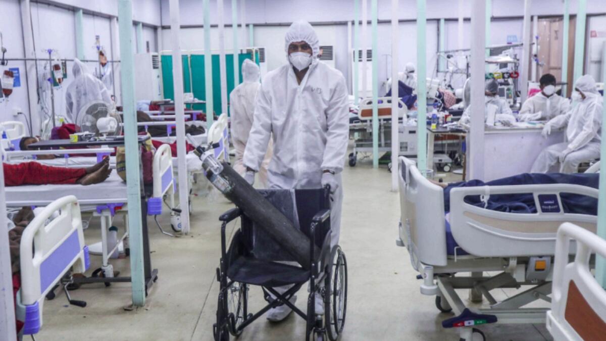 A health worker brings an oxygen cylinder on a wheelchair at the BKC jumbo field hospital in Mumbai. — AP