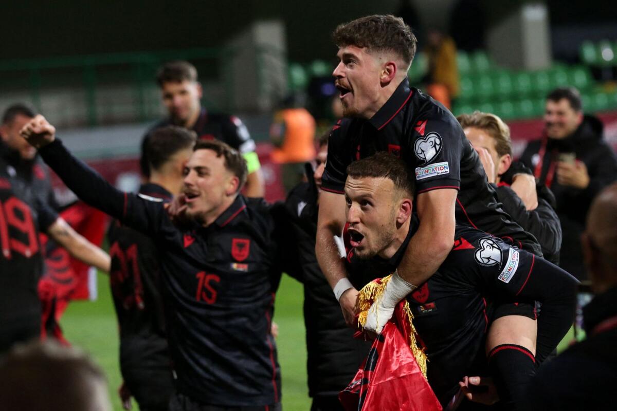 Albanian players celebrate their qualification after the match against Moldova. — AFP