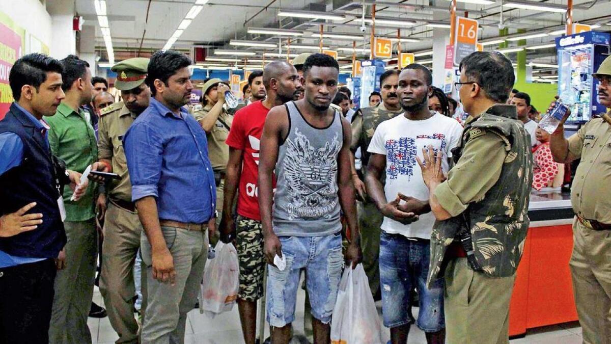 Police and onlookers surrounding African nationals at a shopping mall in Greater Noida. 