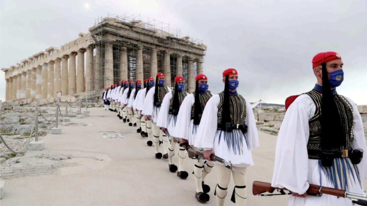 Members of the Presidential Guard walk in front of the Parthenon temple atop of Acropolis Hill in Athens. Greece is among the European countries open for tourists from the UAE. — AP