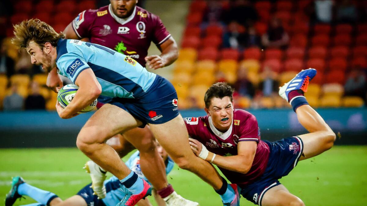 Waratahs' James Ramm (L) is tackled by Reds' Jock Campbell during the Super Rugby match between Australia's Queensland Reds and New South Wales Waratahs at Suncorp Stadium in Brisbane, Australia. Photo: AFP