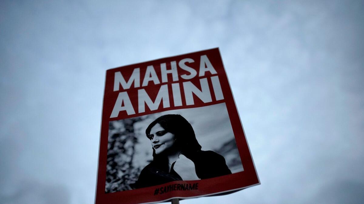 A woman holds a placard with a picture of Mahsa Amini during a protest against her death, in Berlin in 2022. — AP file