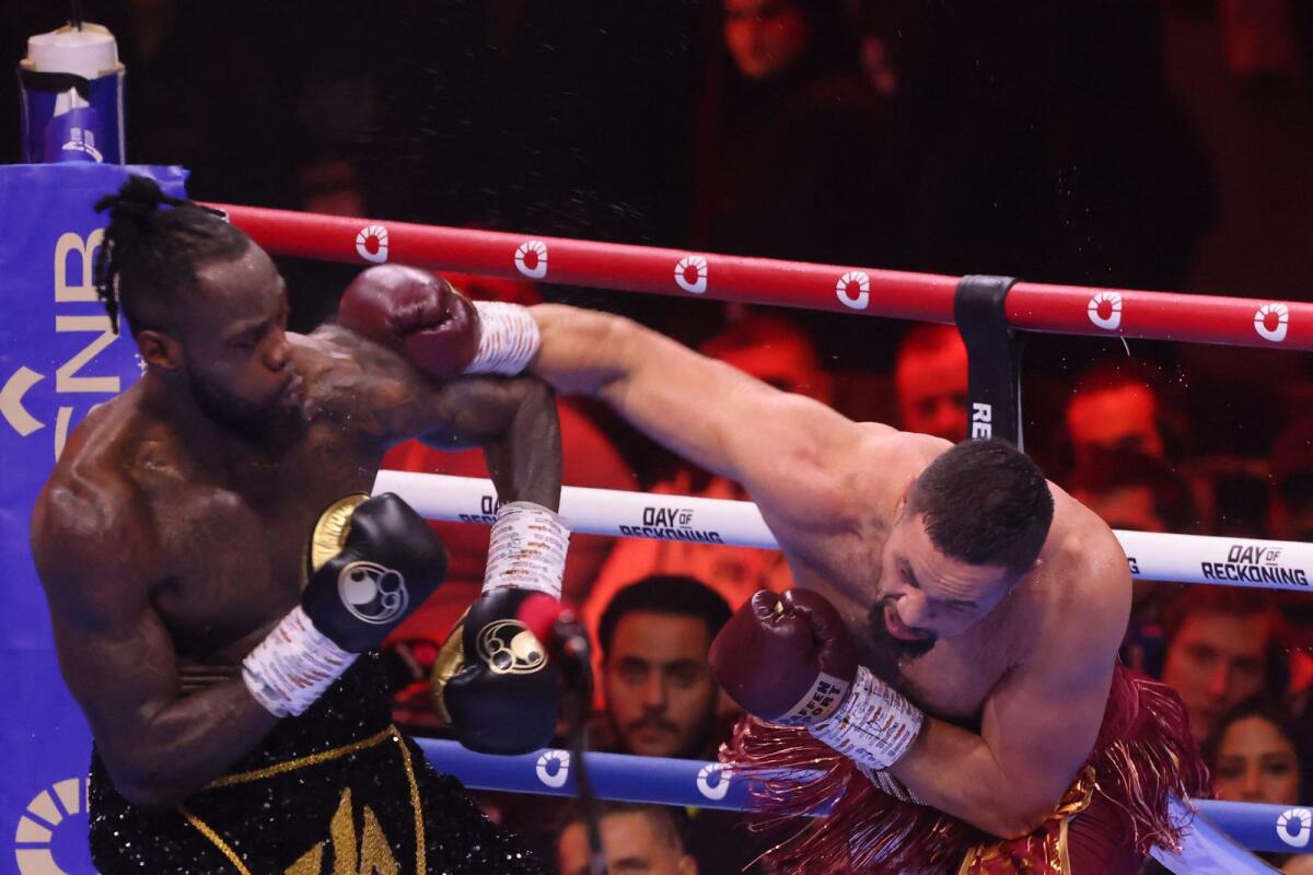 Deontay Wilder (L) covers up as New Zealand's Joseph Parker throws a heavy right during their bout at the Kingdom Arena in Riyadh on December 23. - AFP