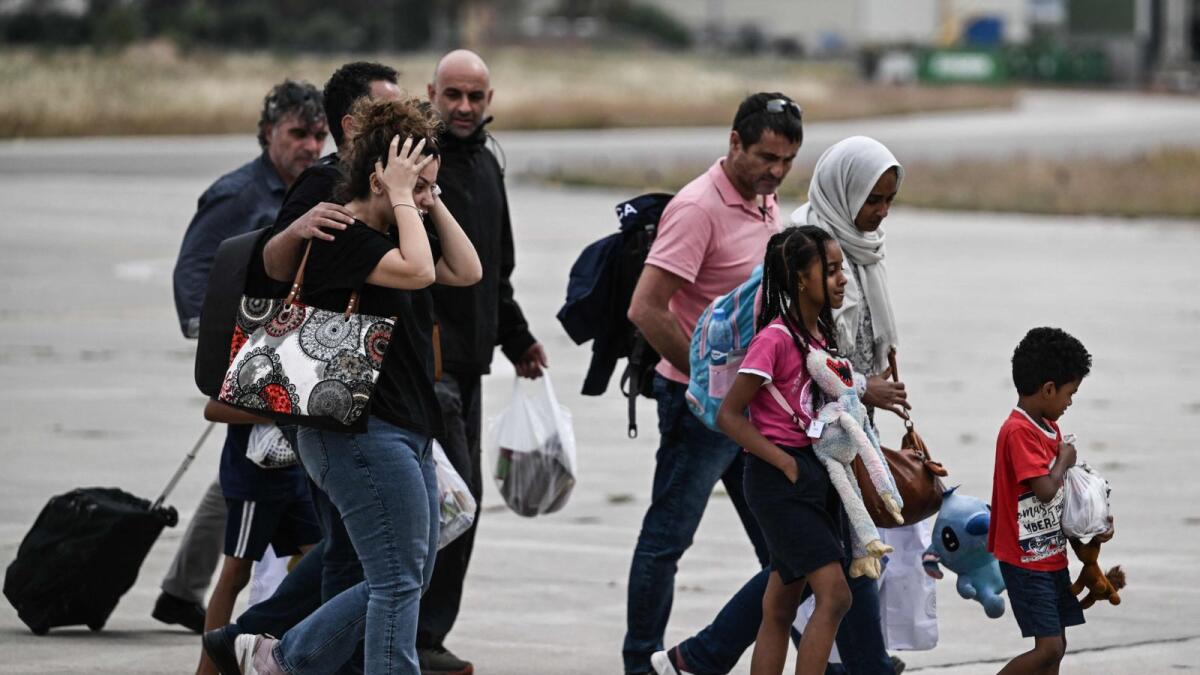 Greek nationals from Sudan arrive with a military C-27 plane at the military airport of Elefsina, south of Athens, on April 25, 2023.  — AFP