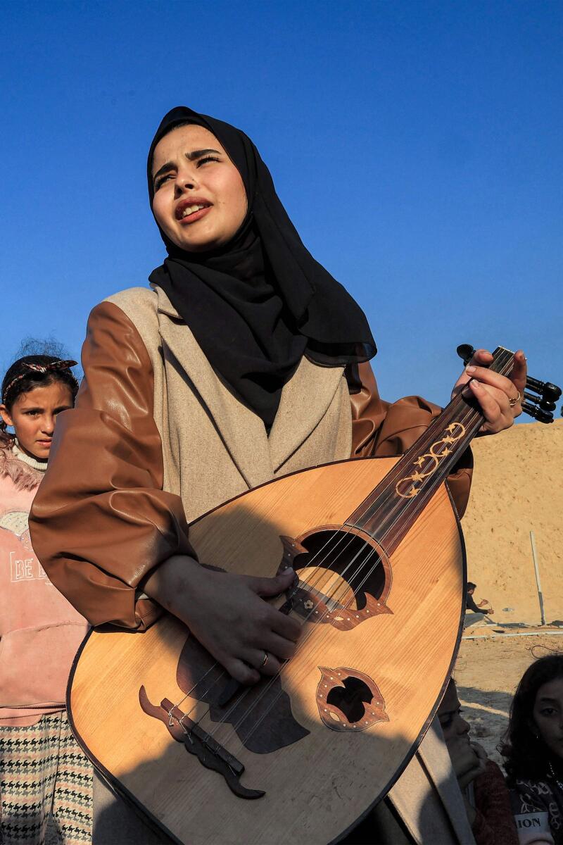 Ruaa Hassouna plays music for Palestinian children on her Oud. — AFP