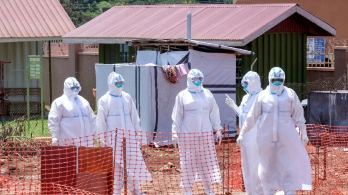 Doctors walk inside the Ebola isolation section of Mubende Regional Referral Hospital in Mubende. — AP