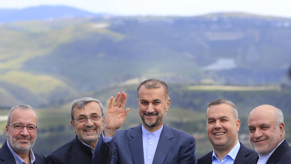 Iranian Foreign Minister Hossein Amirabdollahian waves as he stands with Hezbollah members and lawmakers as the Israeli side seen in the background, during his visit to Iran park, in the village of Maroun el-Rass on the Lebanon-Israel border on April 28, 2023. — AP