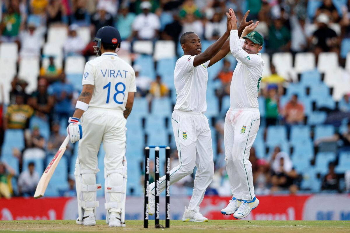 South Africa's Kagiso Rabada (centre) celebrates with Dean Elgar (right) after the dismissal of India's star batsman Virat Kohli. — AFP