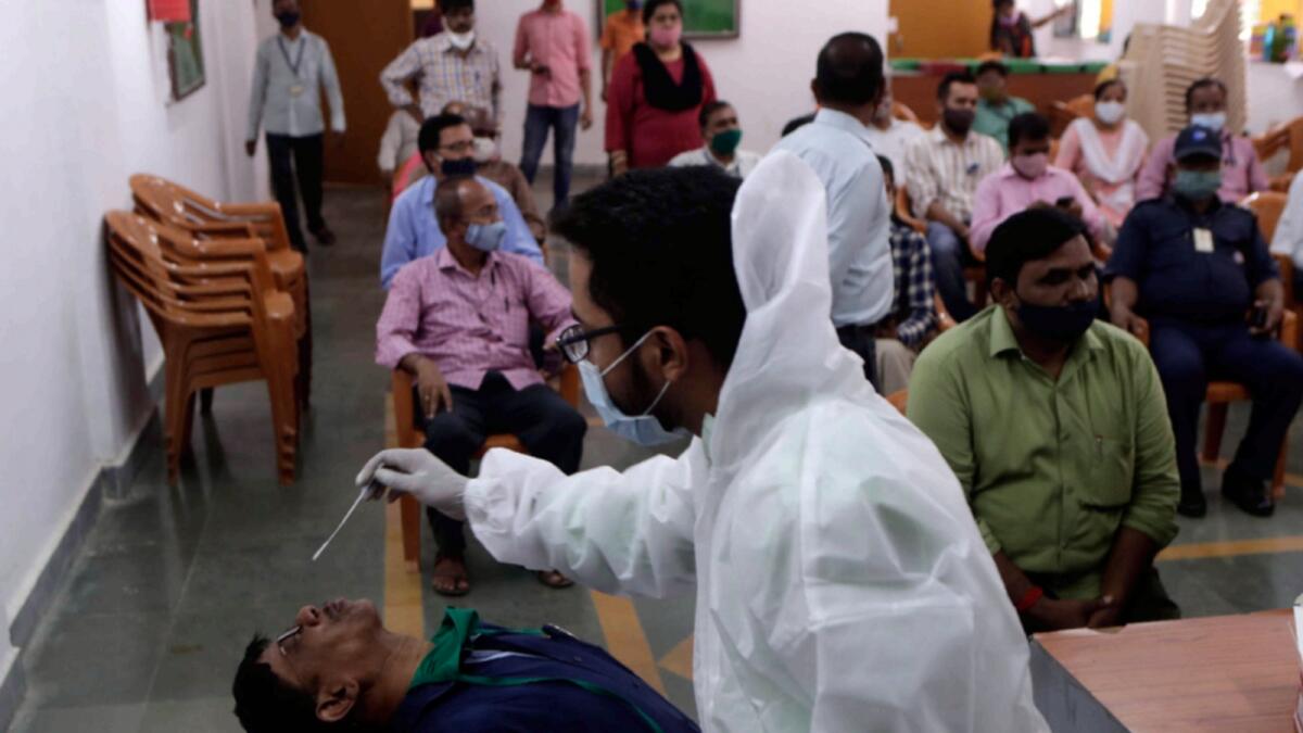 A health worker takes a nasal swab to test for Covid-19 at the Mumbai municipal corporation's educational department in Mumbai. — AP