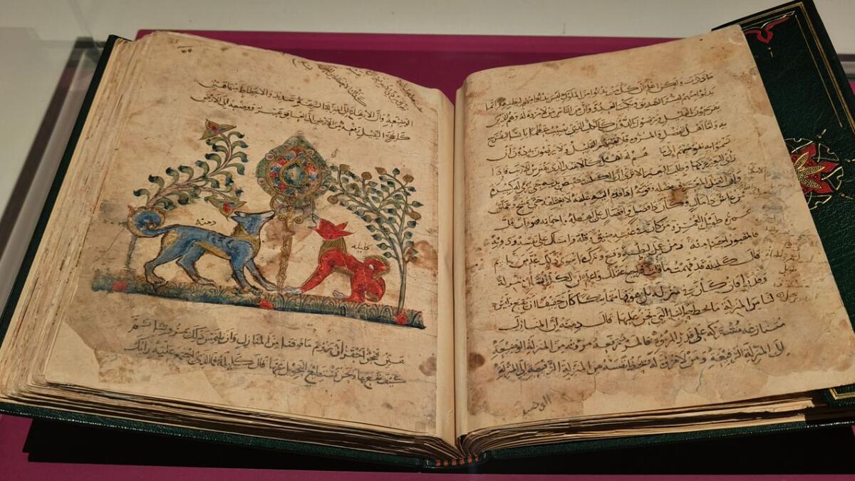 Both the narrators and central characters in the book, the two jackals – Kalila (in red) and Dimna (in blue) – stand on either side of an extraordinary plant that forms a central axis