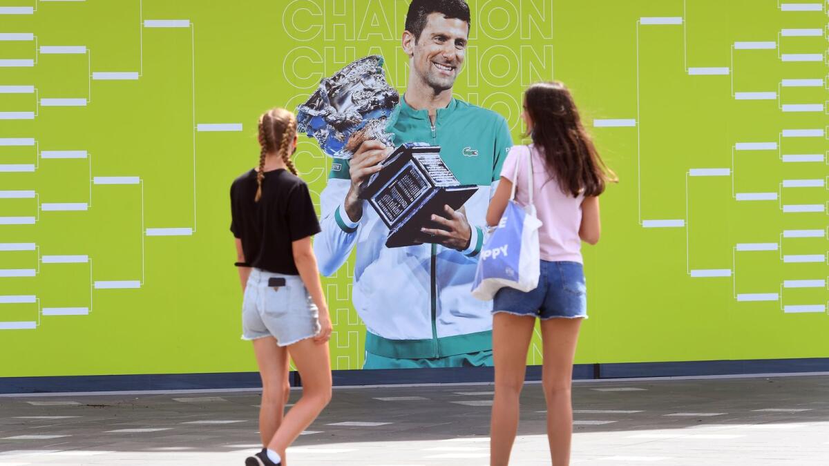 People look at an image of Novak Djokovic at the Melbourne Park tennis centre on Tuesday. (AFP)