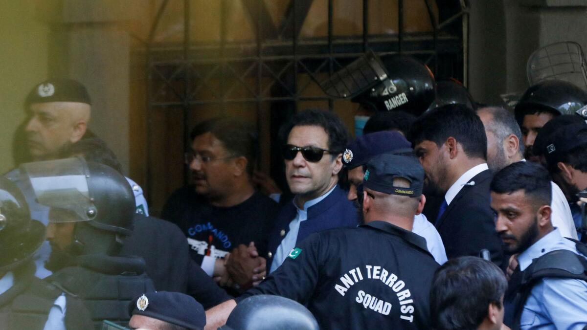 Security officers escort Pakistan's former prime minister Imran Khan, as he appeared in Islamabad High Court. — Reuters
