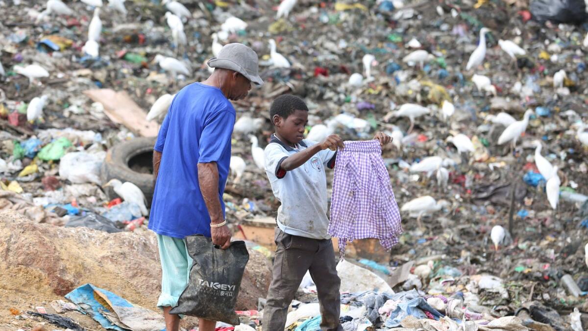 A child looks for clothes at the Mindoube dump in Libreville on June 18, 2021. Dozens of children live and work at the Mindoube dump where they search for copper or aluminium objects to sell.