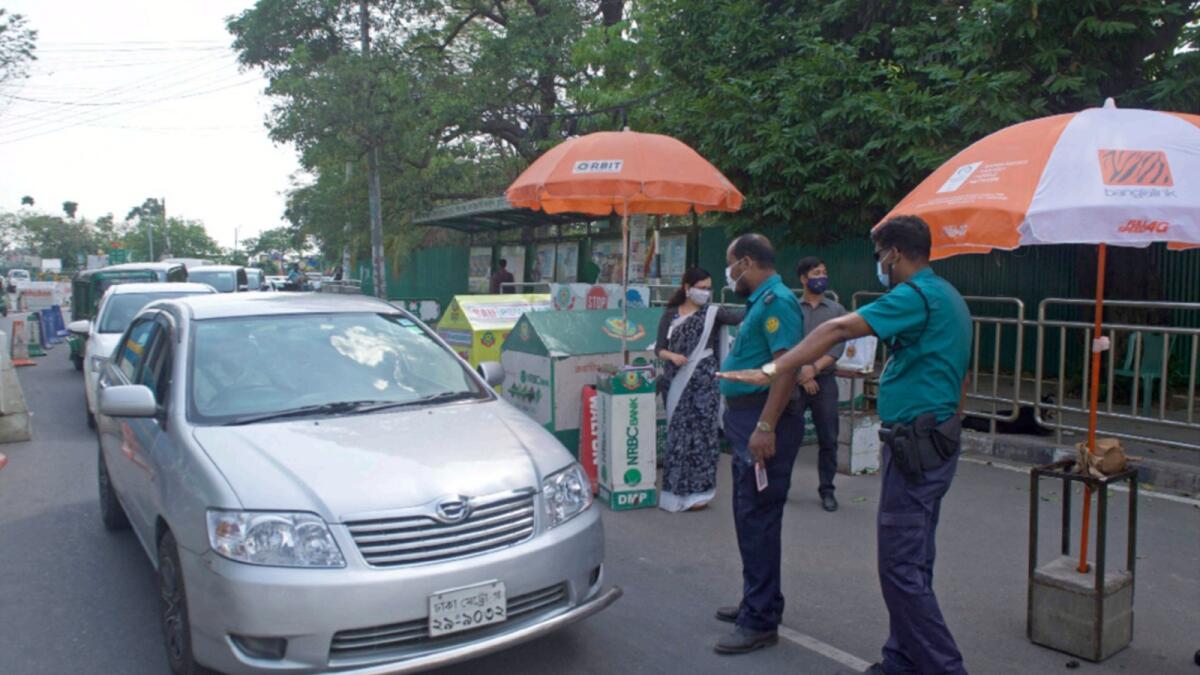 Security personnel check vehicles commuting during the lockdown after authorities imposed nationwide lockdown on Tuesday. — AFP