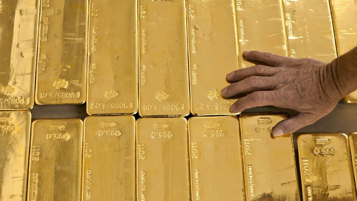 Gold below 13-month top on dollar, heads for second week of gains