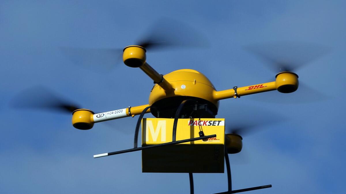 An unmanned aerial vehicle (UAV) carries a parcel in Bonn, Germany. DHL has for the first time tested parcel deliveries with a drone. — AP
